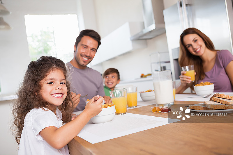 一家人在早餐时对着镜头微笑图片素材