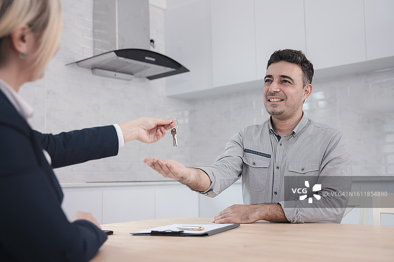 男顾客从房地产经纪人那里收到房屋钥匙图片素材