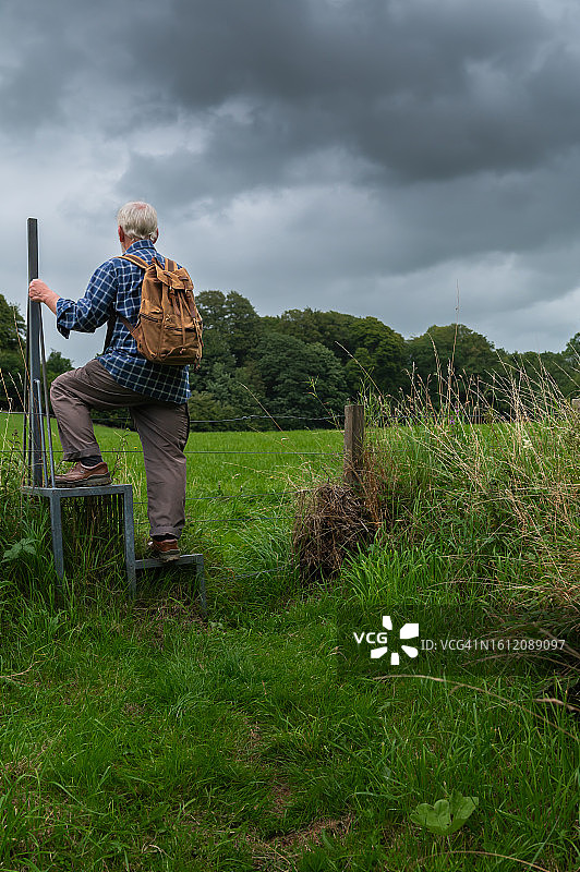 退休老人翻越栅栏图片素材