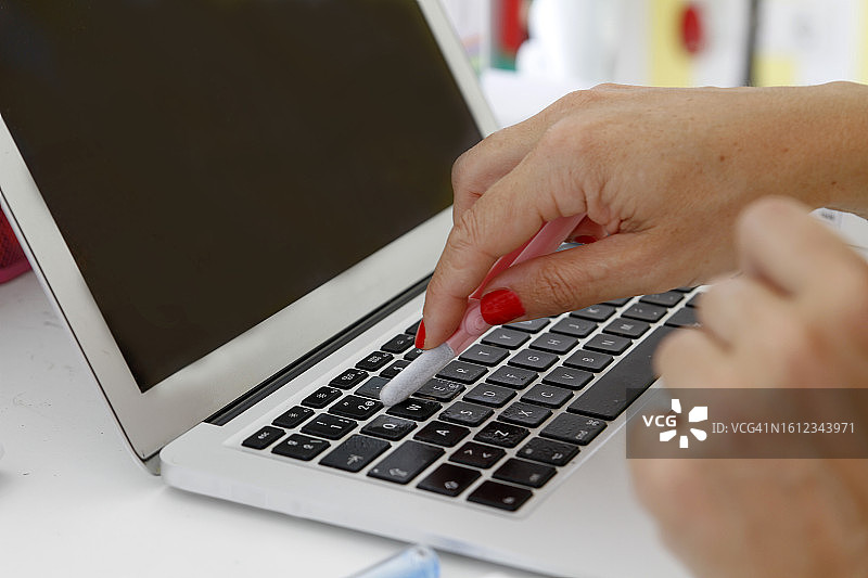 女人清洁笔记本电脑的特写图片素材
