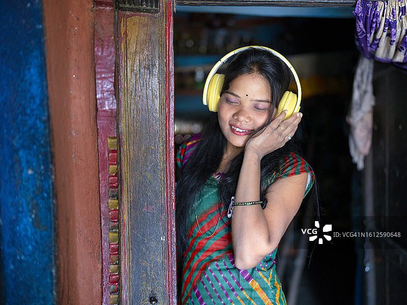 来自印度奥迪沙邦的女孩第一次用耳机听音乐图片素材
