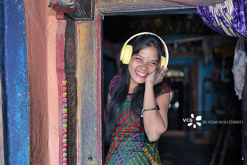 来自印度奥迪沙邦的小女孩第一次戴耳机听音乐图片素材