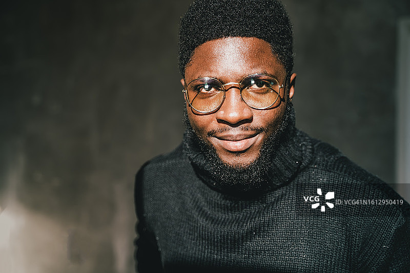 戴时尚眼镜的自信乐观的年轻商人，面带微笑看着镜头图片素材