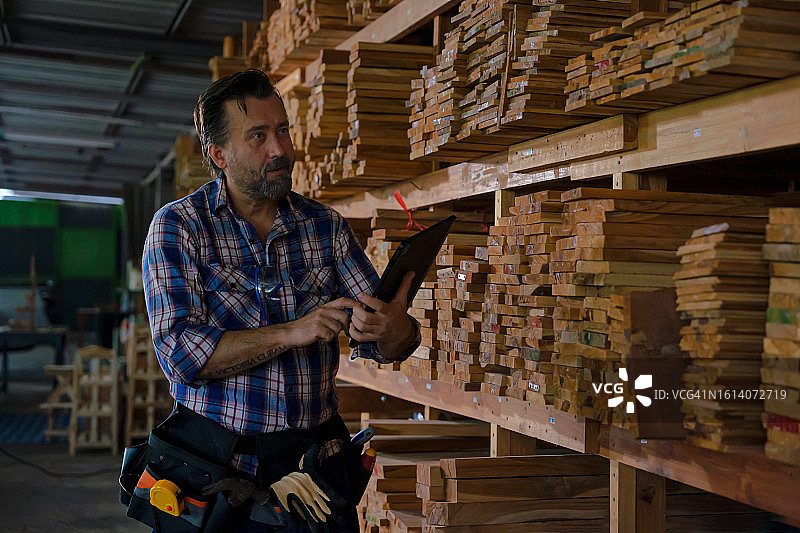 男人从架子上选择木板图片素材