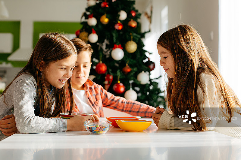 孩子们在桌旁吃糖果图片素材