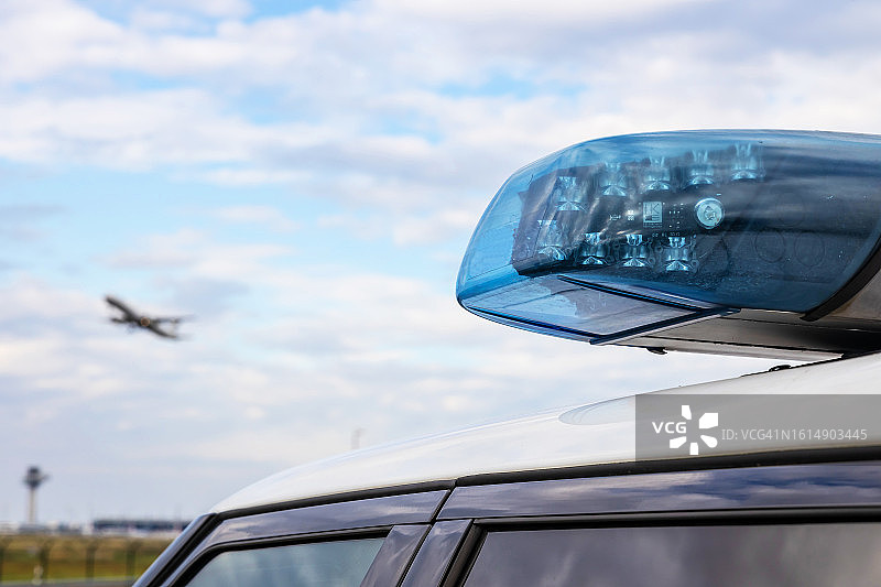 德国警车上的警灯与天空中的客机图片素材