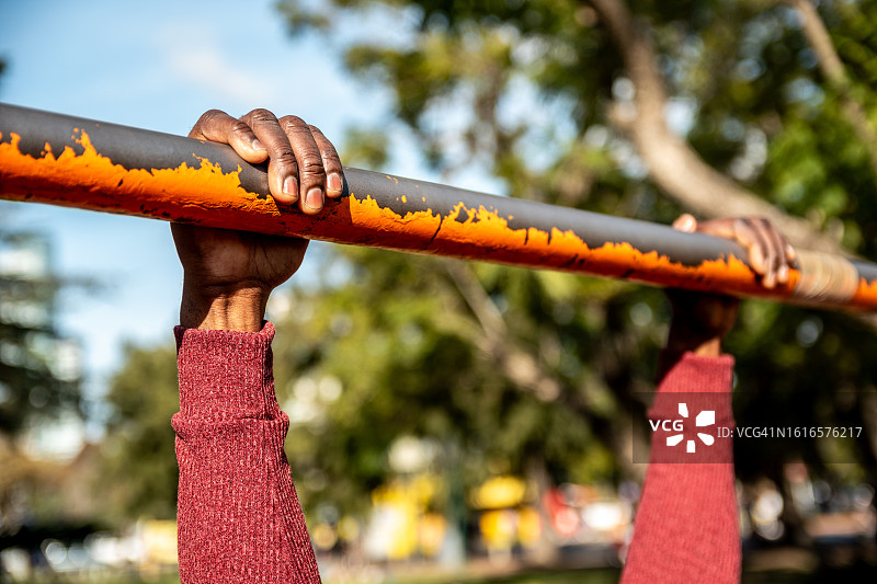 在公园里手扶单杠的特写图片素材