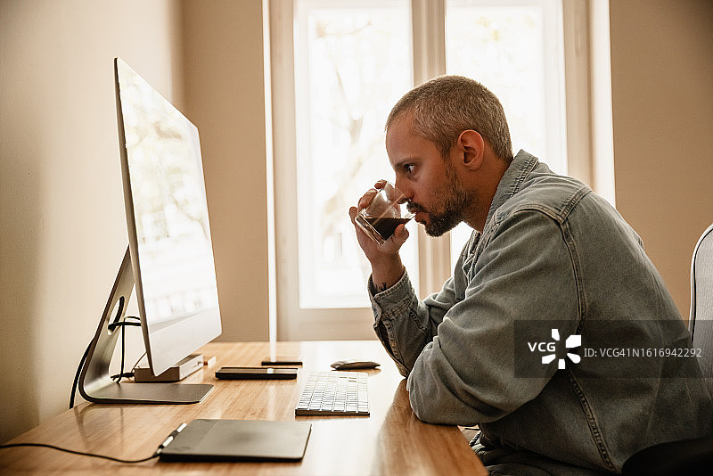 开发者的家庭办公室-在家进行软件开发，一边喝咖啡一边看屏幕图片素材