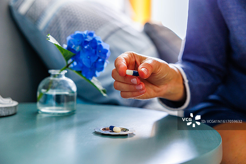 坐在床上，手里拿着药丸的女人图片素材