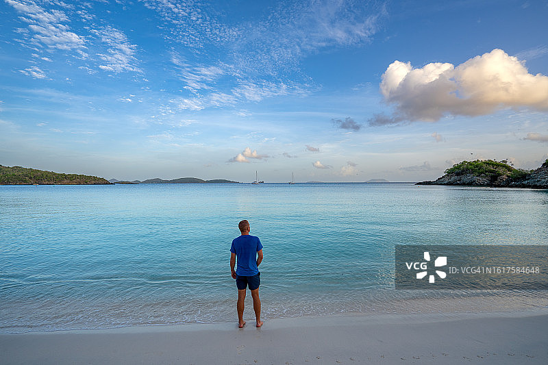 男人在美国维尔京群岛圣约翰热带加勒比海岛屿著名的树干湾享受充满活力的日出图片素材