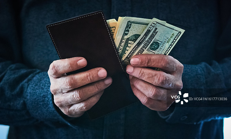 男人手持钱包和现金特写图片素材