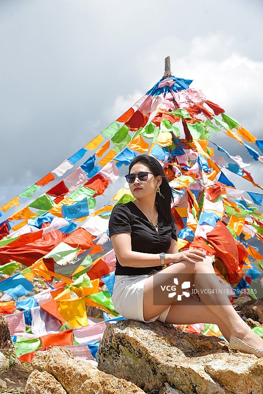 女人坐在山顶上拍照图片素材
