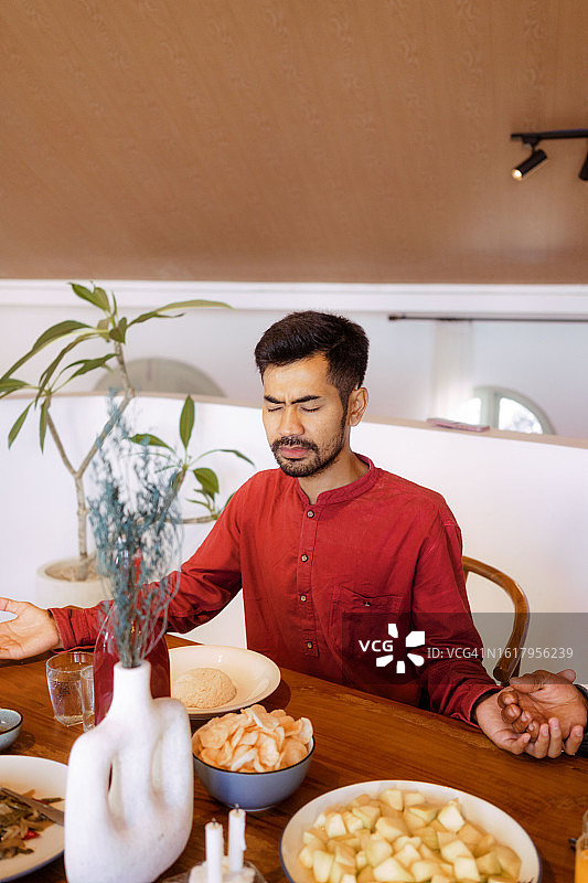 小家庭在餐桌旁餐前祈祷图片素材