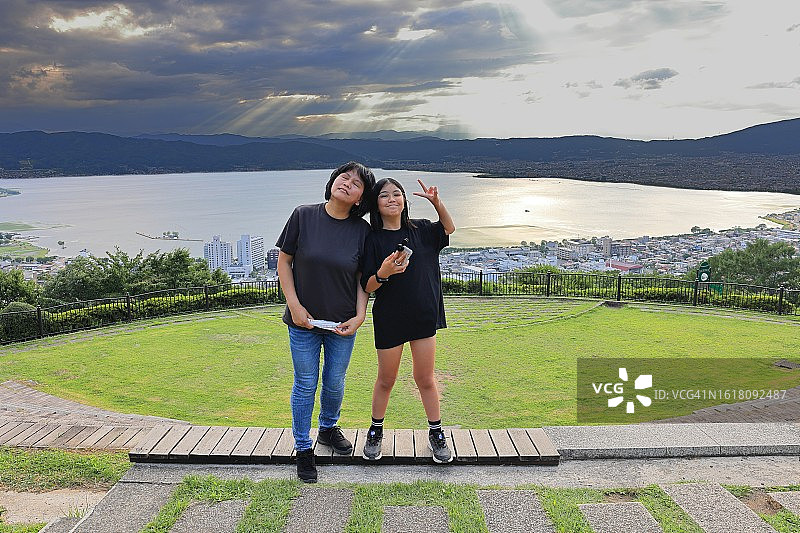 母子在立石公园的宁静场景，母女在诹访湖畔享受亲情图片素材