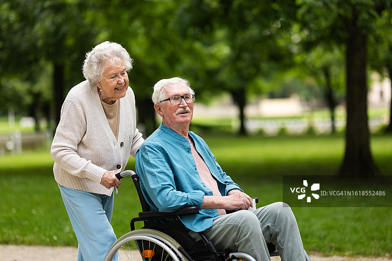 坐在轮椅上的老妇人和她的丈夫在公园里共度时光图片素材