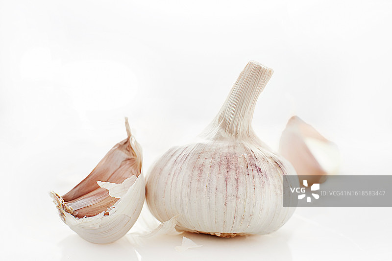 桌子上大蒜鳞茎和蒜瓣的特写图片素材