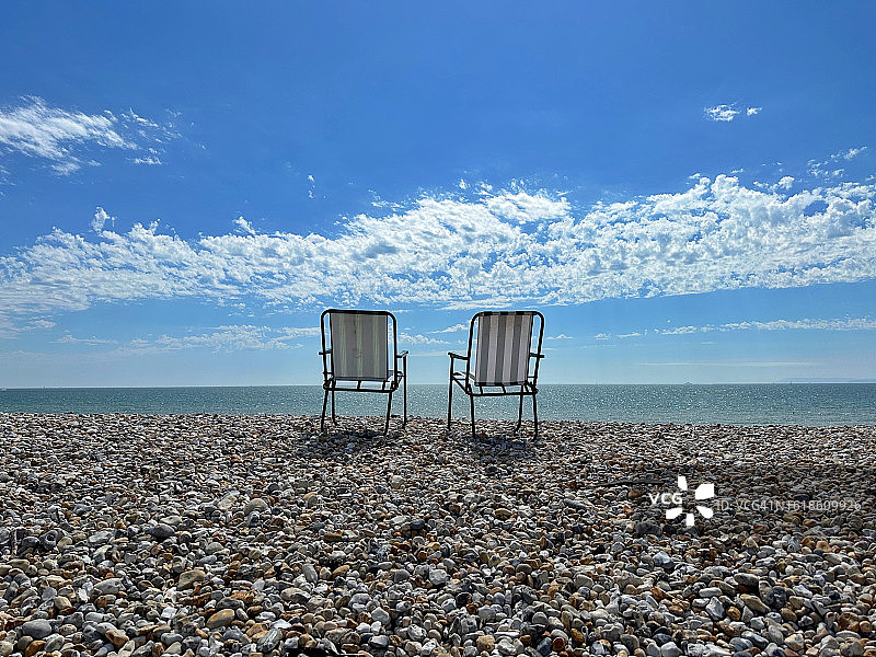 两把折叠花园椅，位于英国西萨塞克斯郡的辛格尔海滩图片素材