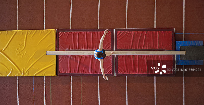 在平衡木上表演的体操女运动员图片素材