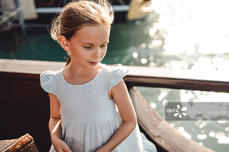 游轮上对着绚丽大海微笑的美丽女孩图片素材