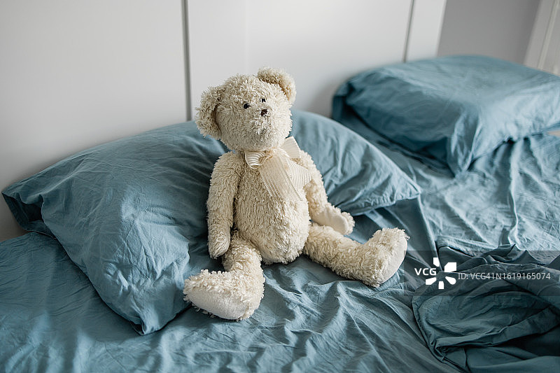 躺在床上的玩具熊：孤独的玩具图片素材