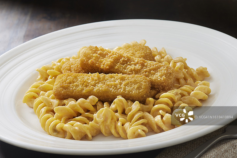 搭配炸鱼条的天鹅绒般顺滑的通心粉和奶酪图片素材