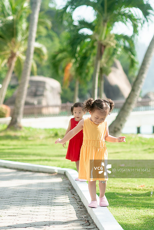 岛屿度假村展示平衡技巧的双胞胎女婴图片素材