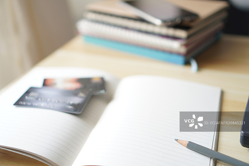 信用卡和铅笔放在笔记本上图片素材