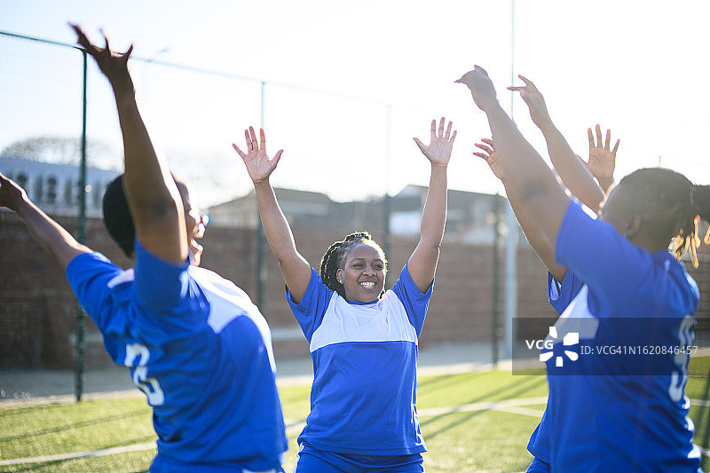 女足球员围在一起举手欢呼图片素材
