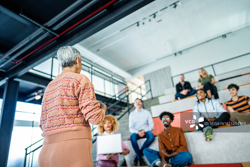 年长的女商人正在办公室或现代大学做演示图片素材