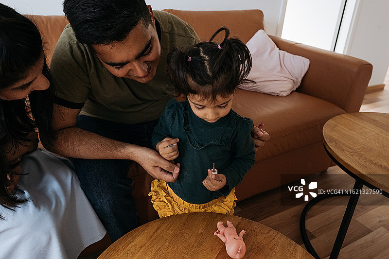 在沙发上玩美甲沙龙的家庭图片素材