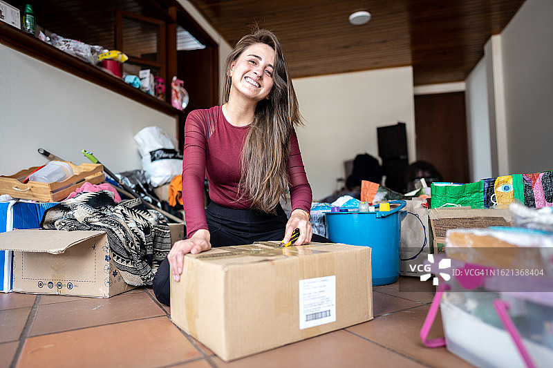 年轻女子在新公寓搬家时打开盒子的 портрет图片素材