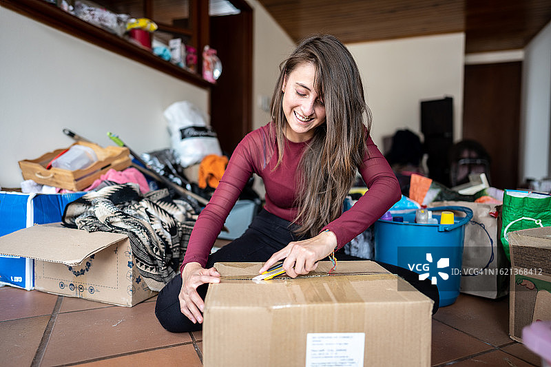 年轻女人在新公寓搬家时打开箱子图片素材
