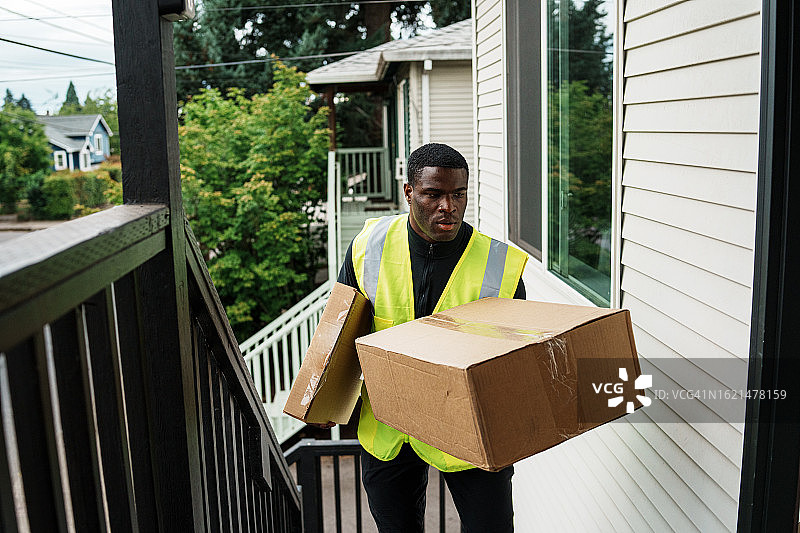 送货员走上楼梯，放下包裹图片素材