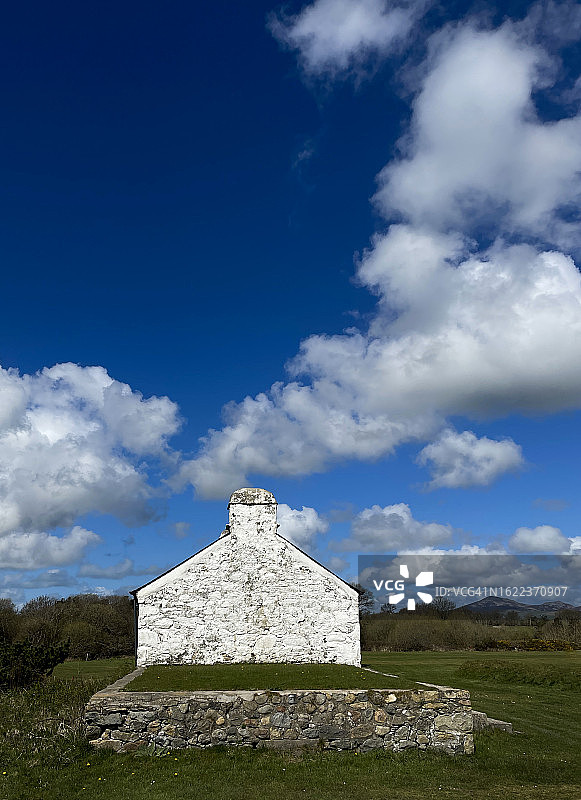 蓝色夏日天空下的白色小屋山墙图片素材