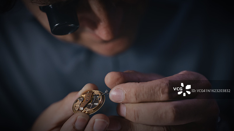男修理工在修理店调整手表齿轮的特写图片素材