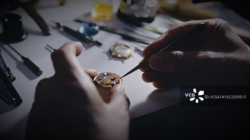 修理工在工作场所修理手表齿轮图片素材
