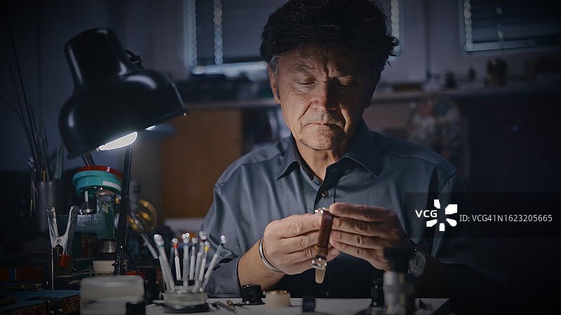 男钟表匠在修理店检查手表图片素材