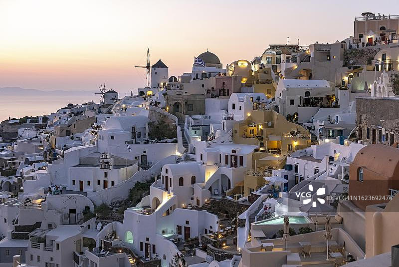 希腊圣托里尼伊亚村悬崖边的房屋别墅和风车夜景图片素材