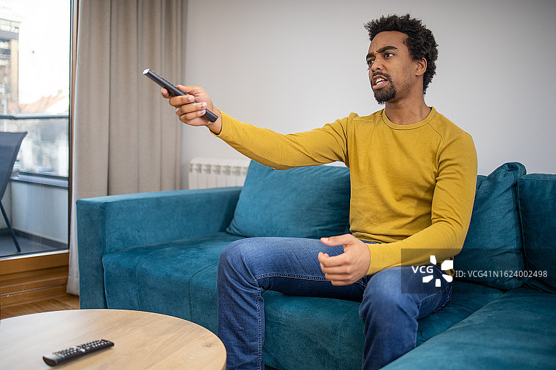 男子在家观看最喜欢的电视节目图片素材