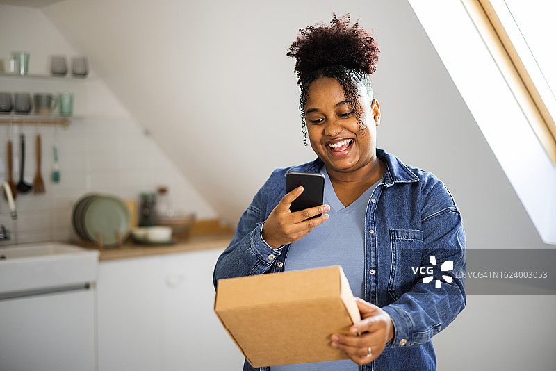 快乐的非裔美国女孩在线支付收到的包裹图片素材