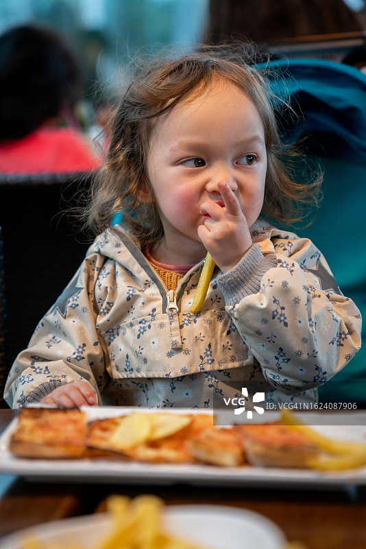 吃炸薯条的儿童肖像图片素材