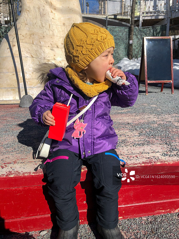 冬天户外女孩吃零食图片素材