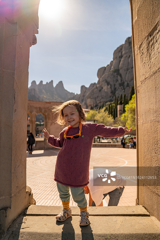 孩子在西班牙蒙尼斯特罗尔的蒙特塞拉特探索古老建筑图片素材