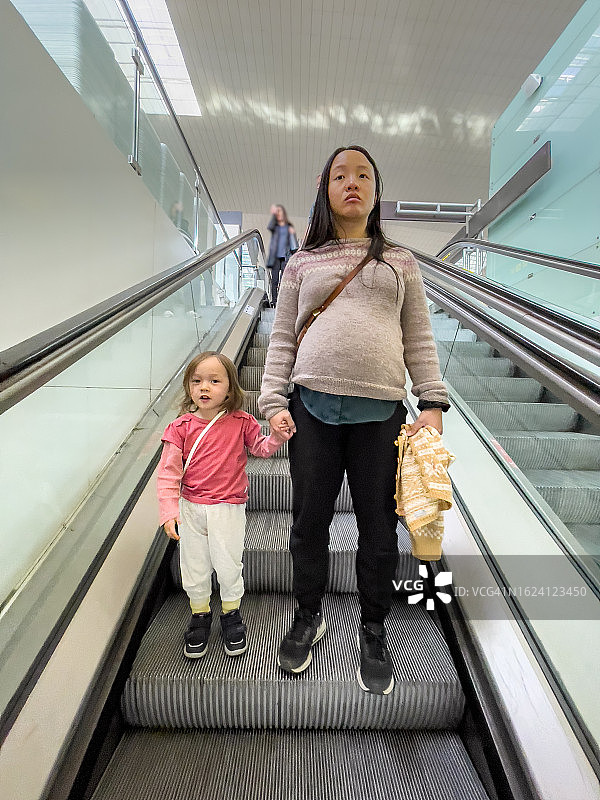 母女乘坐自动扶梯图片素材