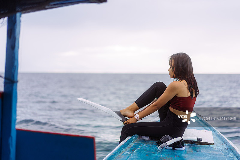 亚洲女性在木船上准备苏拉威西岛塞拉亚岛的浮潜之旅图片素材