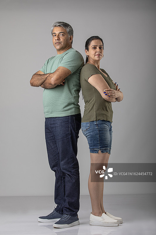 生气的情侣背靠背站在白色背景前图片素材