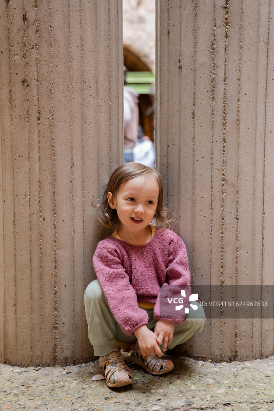孩子在两根柱子间摆姿势图片素材