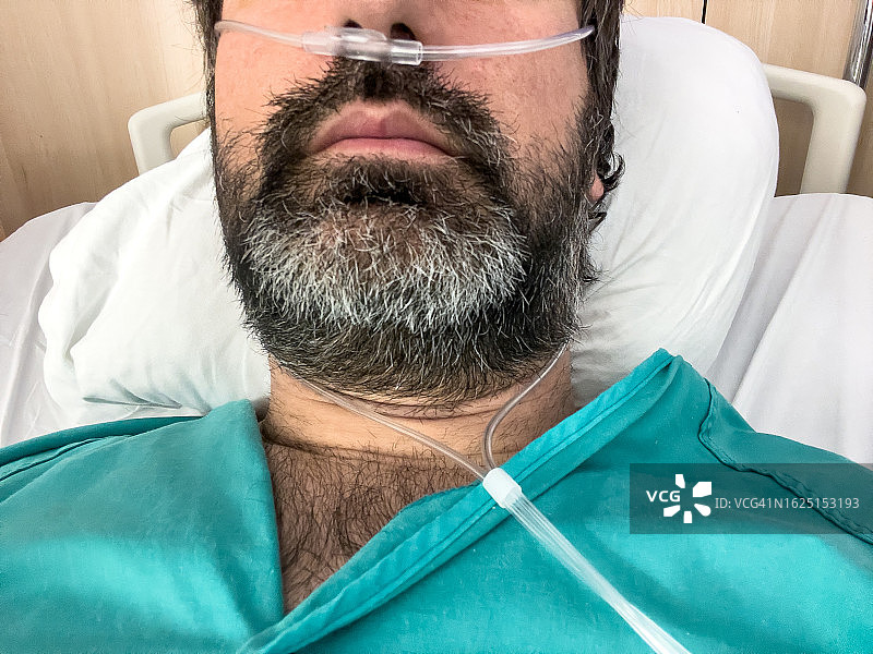 在医院病床上接受氧气的匿名男人图片素材