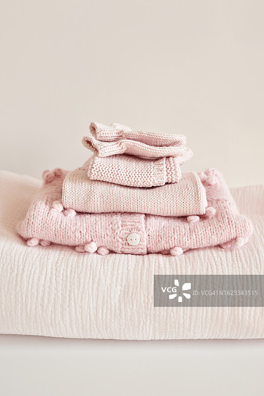 木制架子上的手工针织婴儿服装、新生儿用品和儿童服装图片素材