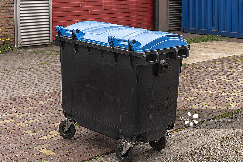 带蓝色盖子的黑色塑料垃圾桶图片素材